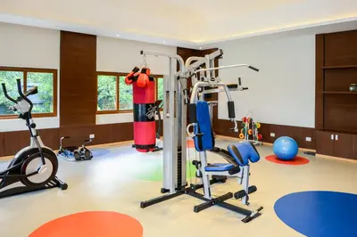 a gym with a treadmill and exercise equipment at Purple Palms Resort & Spa in Kushālnagar