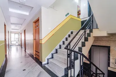 a staircase in a house with a yellow stair case at FabHotel ESS Paradise in Coimbatore