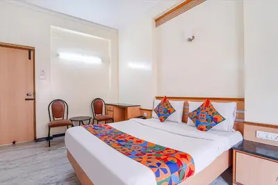a bedroom with a large bed with a colorful comforter at FabHotel ESS Paradise in Coimbatore