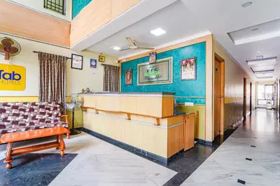 a waiting room with a couch and a table at FabHotel ESS Paradise in Coimbatore
