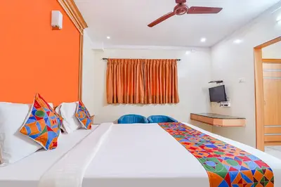 a bedroom with a large bed and a tv at FabHotel ESS Paradise in Coimbatore