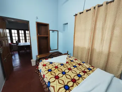 a bedroom with a bed in a room with curtains at Green Acres Farm Guest House in Masinagudi