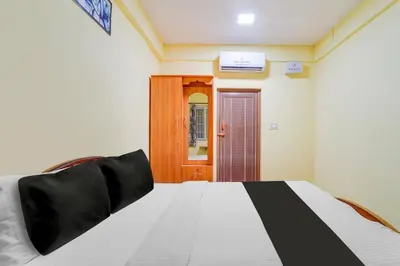 a bedroom with a bed with a black and white blanket at Super Hotel O Airport Road Coimbatore in Coimbatore