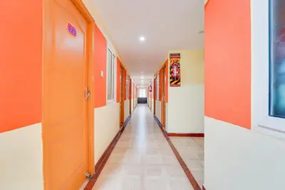 an empty corridor of a school hallway with orange walls at Super Hotel O Airport Road Coimbatore in Coimbatore