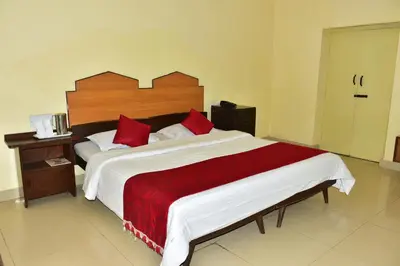 a bedroom with a large bed with red pillows at KSTDC Hotel Mayura Sudarshan ,Ooty in Ooty