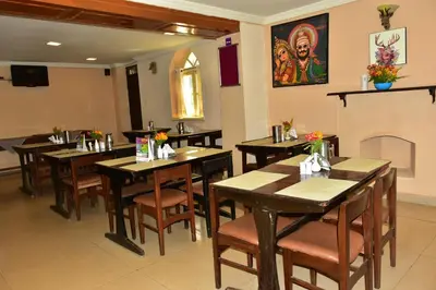 a restaurant with wooden tables and chairs and a fireplace at KSTDC Hotel Mayura Sudarshan ,Ooty in Ooty