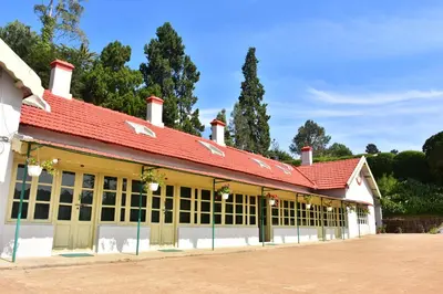a building with a red roof and a lot of windows at KSTDC Hotel Mayura Sudarshan ,Ooty in Ooty
