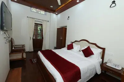 a bedroom with a large bed with red pillows at KSTDC Hotel Mayura Sudarshan ,Ooty in Ooty