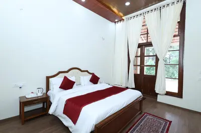 a bedroom with a large bed and a window at KSTDC Hotel Mayura Sudarshan ,Ooty in Ooty