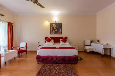 a large bedroom with a large bed and a table at KSTDC Hotel Mayura Kauvery KRS in Hosa Kannambādi