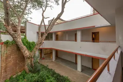 an external view of a house with a tree at KSTDC Hotel Mayura Sangama Mekedatu in Mulhalli
