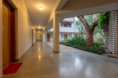 an empty hallway of a building with a tree at KSTDC Hotel Mayura Sangama Mekedatu in Mulhalli