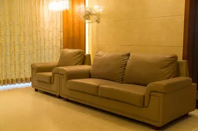 a couch and a chair in a living room at Hotel Sri Sakthi in Tiruppūr