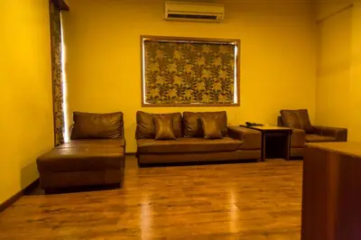 a living room with a couch and two chairs at Hotel Sri Sakthi in Tiruppūr