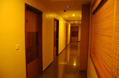 a hallway with yellow walls and wooden doors at Hotel Sri Sakthi in Tiruppūr