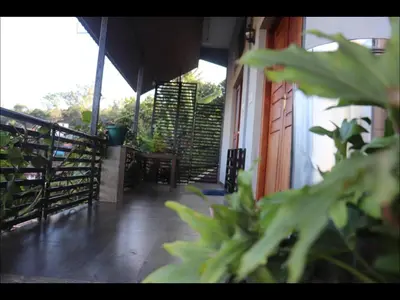 a balcony with a table and chairs and plants at Coorg North Breeze Homestay in Madikeri