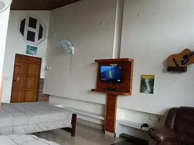 a living room with a tv on the wall at Coorg North Breeze Homestay in Madikeri