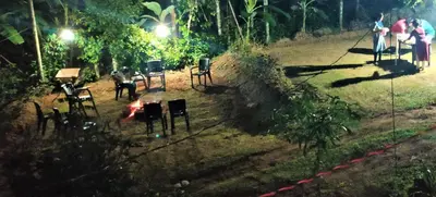 a group of people standing in a yard with chairs at Gooseberry Family Retreats - Wayanad by KARAPUZHA RESORTS in Meenangadi