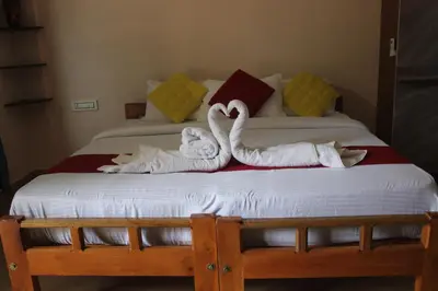 two swans towels sitting on top of a bed at Gooseberry Family Retreats - Wayanad by KARAPUZHA RESORTS in Meenangadi