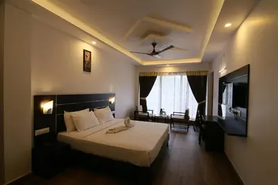 a hotel room with a bed and a television at Jays Inn in Munnar