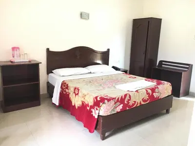 a bedroom with a bed with a red blanket and a night stand at Jays Inn in Munnar