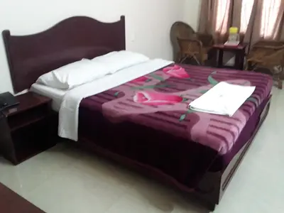 a bed with a purple blanket on it in a room at Jays Inn in Munnar