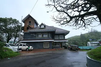 a house with cars parked in front of it at Jays Inn in Munnar