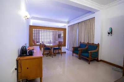 a hotel room with a table and chairs and a room at Casino Hotels Ltd in Trichūr