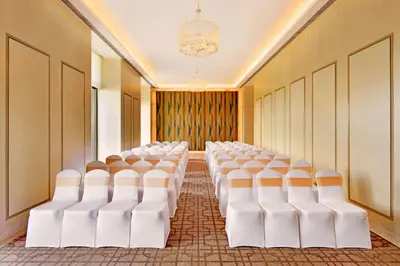 a room with rows of white chairs in a room at Radisson Blu Coimbatore in Coimbatore