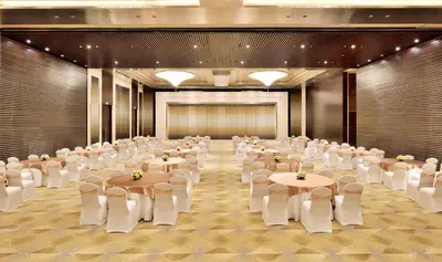 a large banquet hall with tables and white chairs at Radisson Blu Coimbatore in Coimbatore