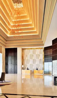 a lobby with a chandelier and a large room at Radisson Blu Coimbatore in Coimbatore