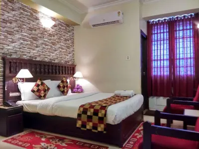 a bedroom with a bed and a brick wall at Hotel Palace Tower in Trichūr