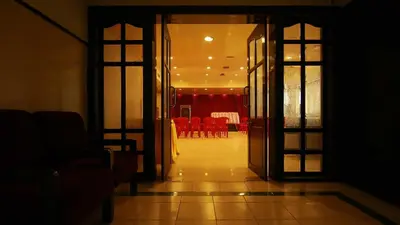 an open door to a dining room with red chairs at Hotel Palace Tower in Trichūr