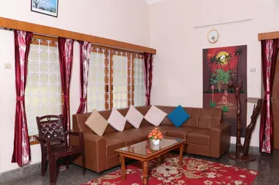 a living room with a brown couch and a table at Park corner Home stay in Coonoor