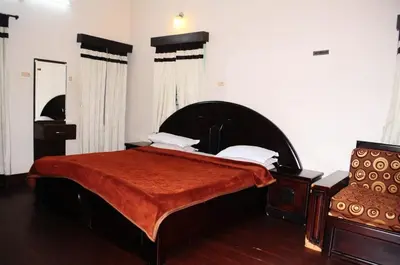 a bedroom with a large bed with a red blanket at Park corner Home stay in Coonoor
