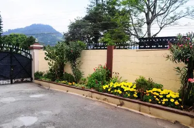a fence with a bunch of flowers in a yard at Park corner Home stay in Coonoor