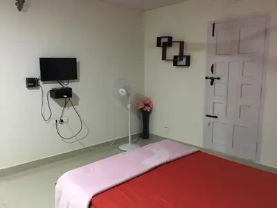 a bedroom with a red bed and a door at Vacanza Estate House in Kakkabe