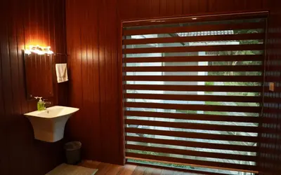 a bathroom with a shower with a sink and a mirror at Woodrose Resort in Kalpetta