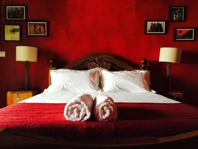 a bed with two towels on a red blanket at Majo House in Cherai Beach