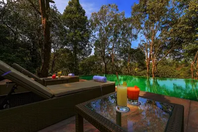 a glass table with a drink on top of it at Wayanad Wild - A CGH Earth Experience in Vythiri