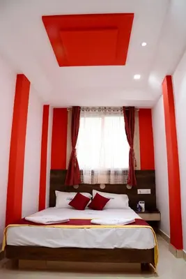 a bedroom with red and white walls and a bed at Hotel Landmark in Ooty