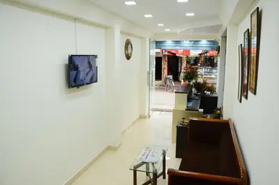 a hallway with a couch and a tv on a wall at Hotel Landmark in Ooty