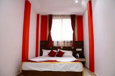 a bedroom with a bed with red and white walls at Hotel Landmark in Ooty