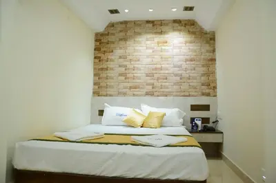 a bedroom with a large bed with a brick wall at Hotel Landmark in Ooty