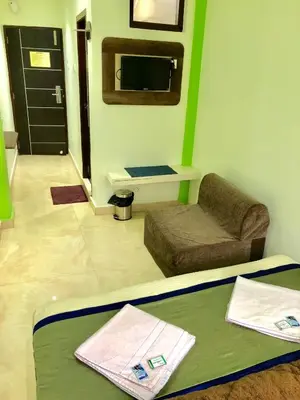 a living room with a couch and a tv at Hotel Landmark in Ooty