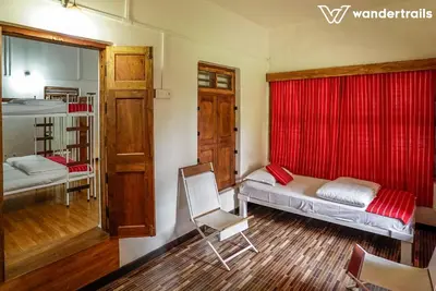 a bedroom with a bed and a red curtain at Teak Town in Nilambūr