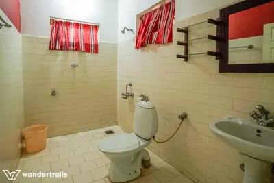a bathroom with a toilet and a sink at Teak Town in Nilambūr