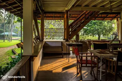 a porch of a restaurant with a table and chairs at Teak Town in Nilambūr