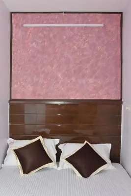 a large window above a bed with two pillows at Arunaachalaa Inn in Palani