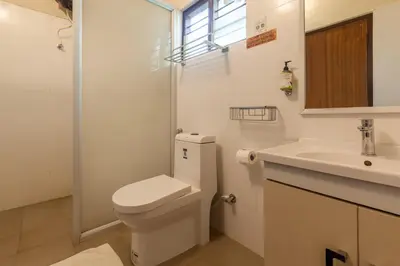 a white bathroom with a toilet and a sink at Treebo Vrindavan, 3 Km From Madikeri Fort in Madikeri